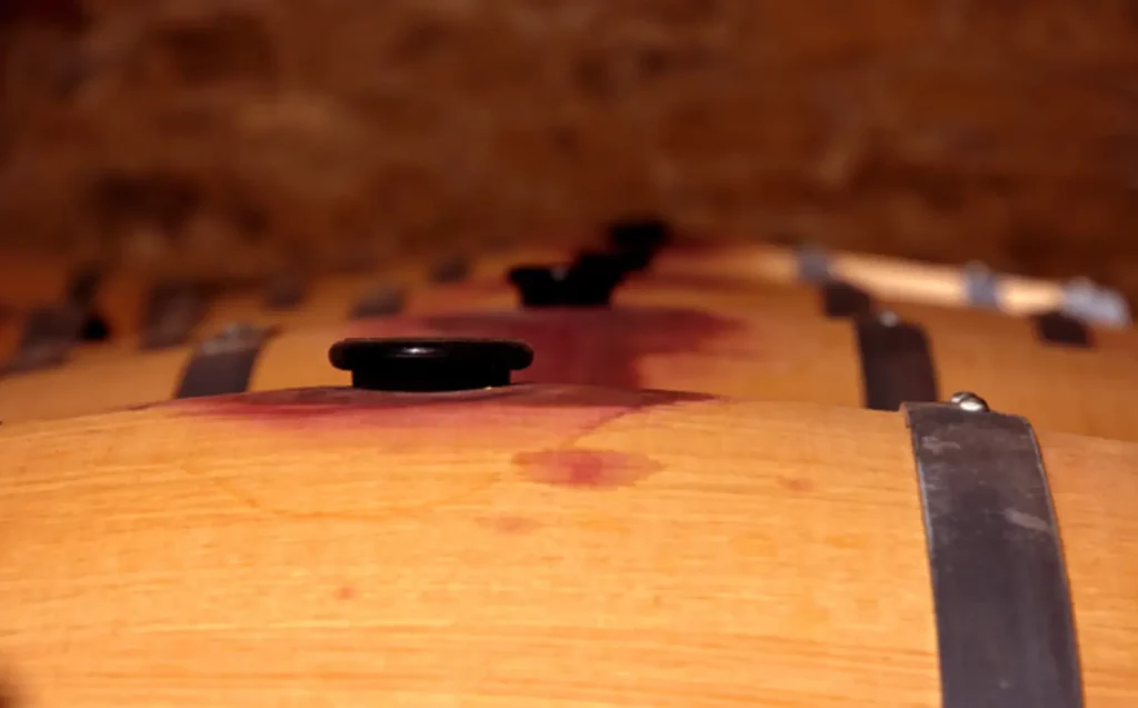 drevené sudy naplnené červeným vínom